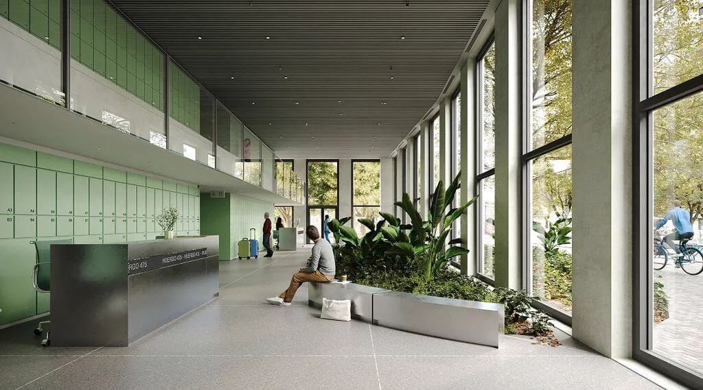 El lobby del edificio es una extensión del espacio verde urbano, lleno de luz y vegetación.